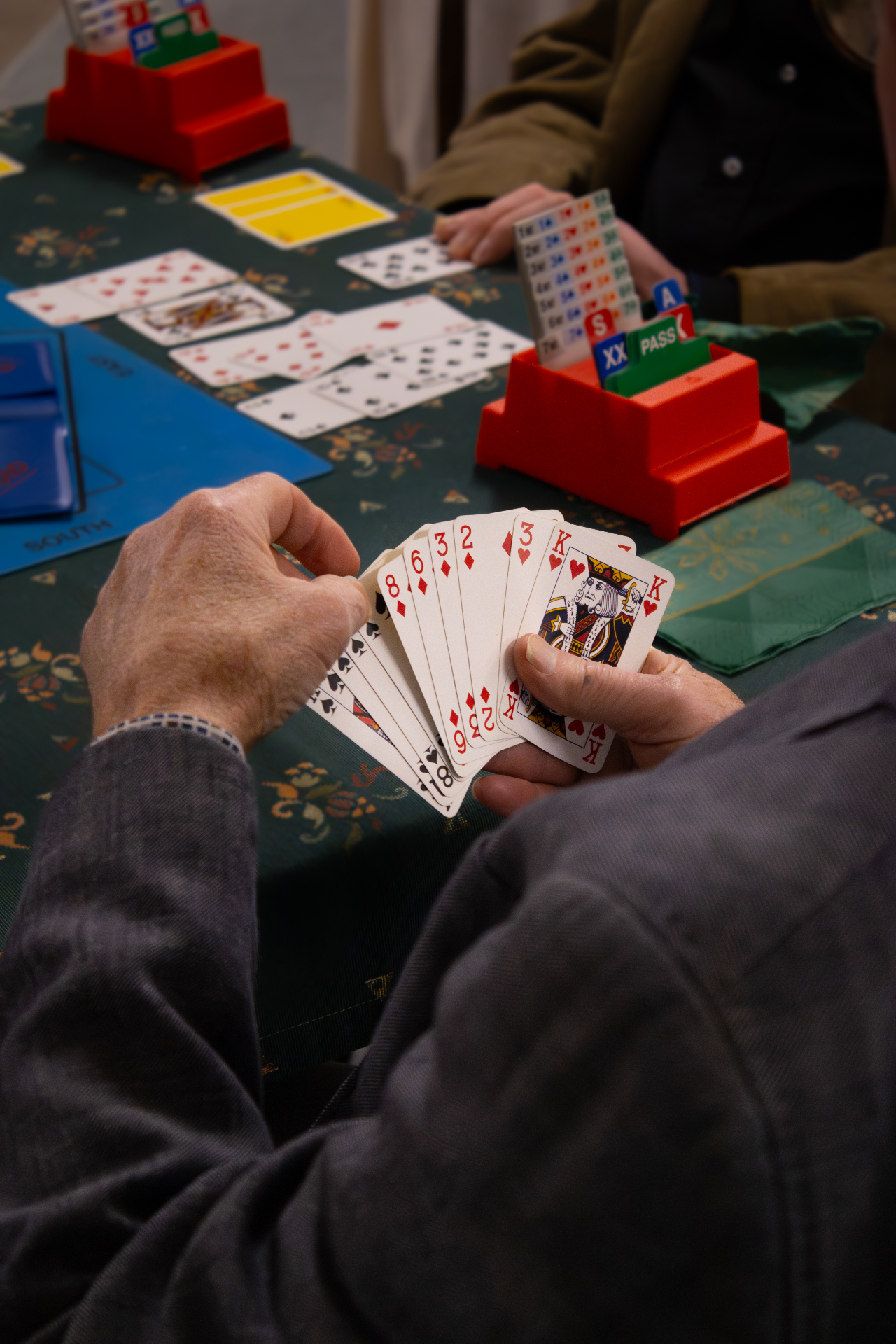 Close-up van bridgekaarten en biedbox op de speeltafel