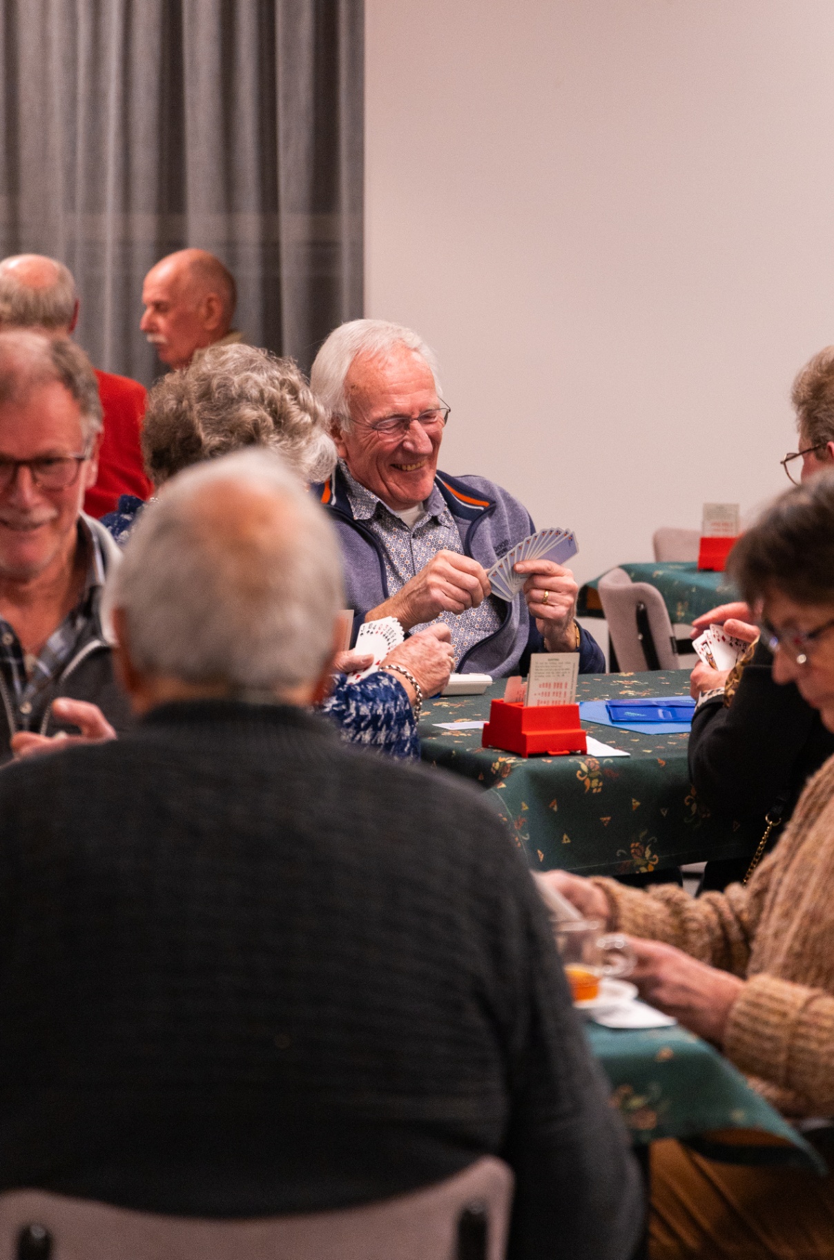 Clubleden samen aan tafel tijdens een gezellige bridgeavond